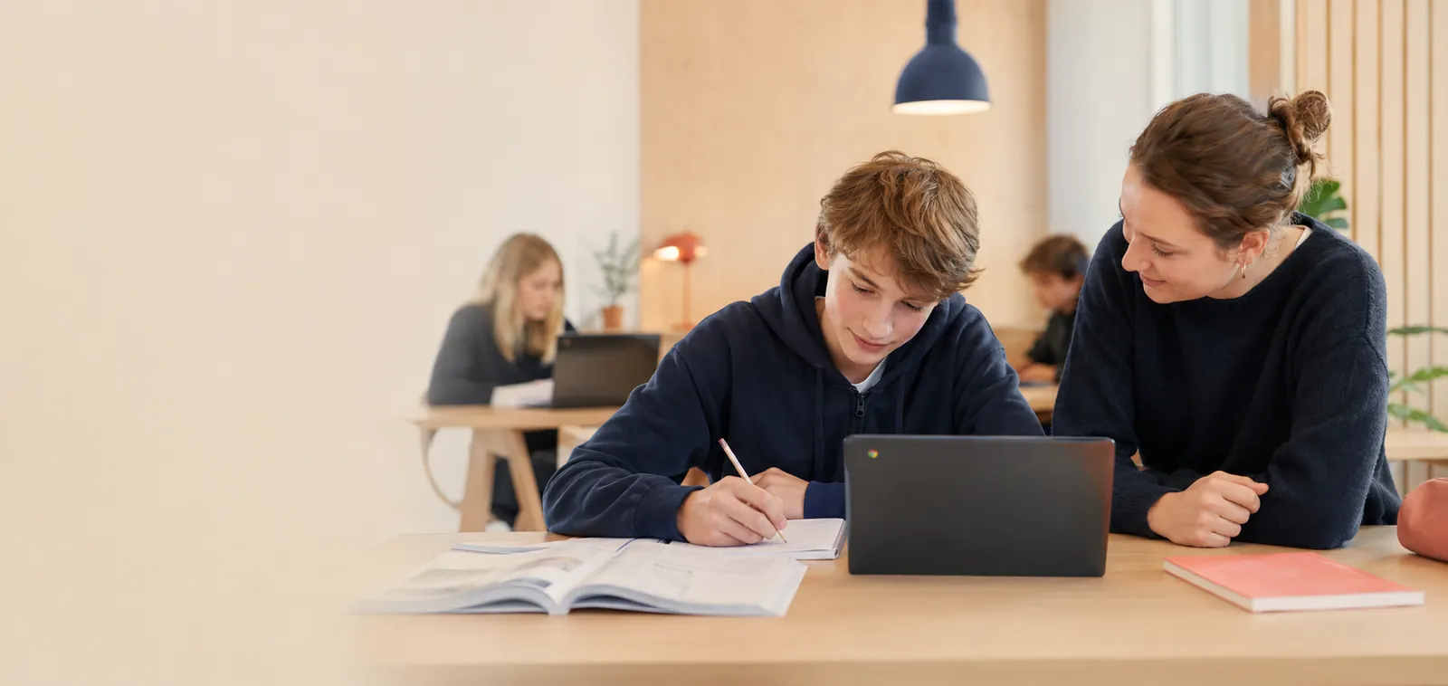 Elev och lärare som arbetar tillsammans med matematik vid en Chromebook